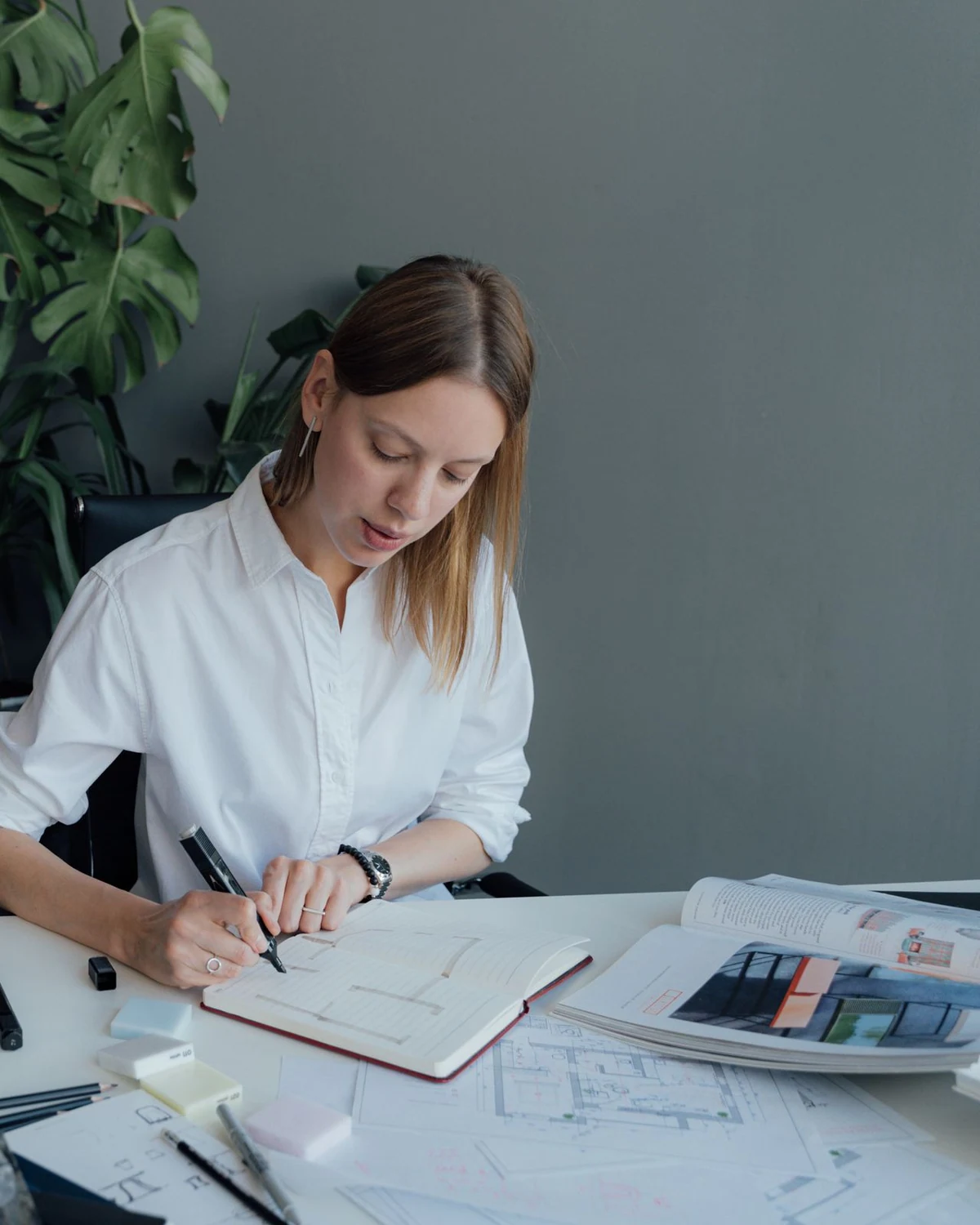 A young residential designer sketching plans at her desk